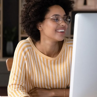 Young woman smiles at her computer screen